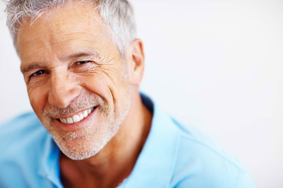 older man in teal shirt smiling | veneers cheshire ct