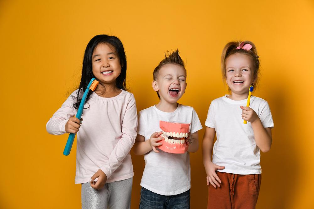 three young kids holding toothbrushes | childrens dentist cheshire ct