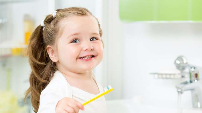 small child holding toothbrush | children's dentist near me