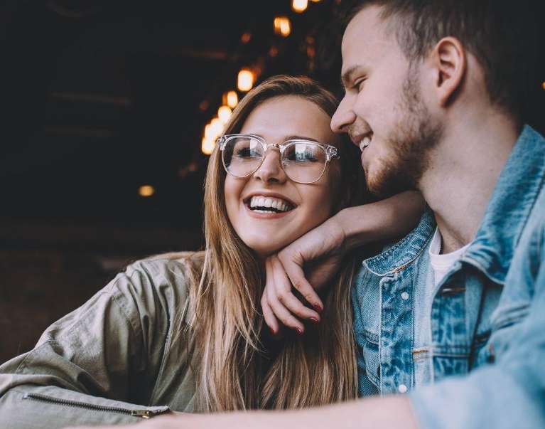 woman with glasses smiling with partner | dental crowns cheshire ct
