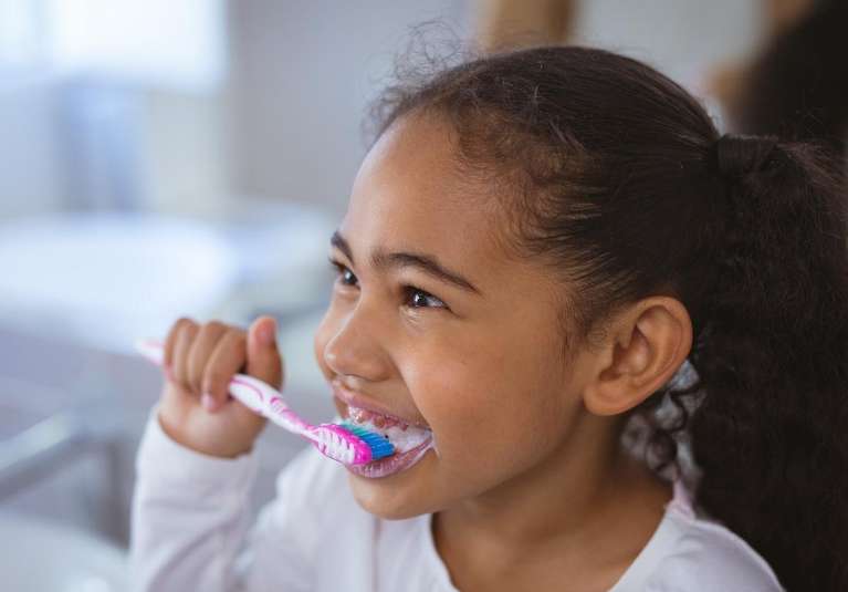 young girl brushing teeth | childrens dentist near me