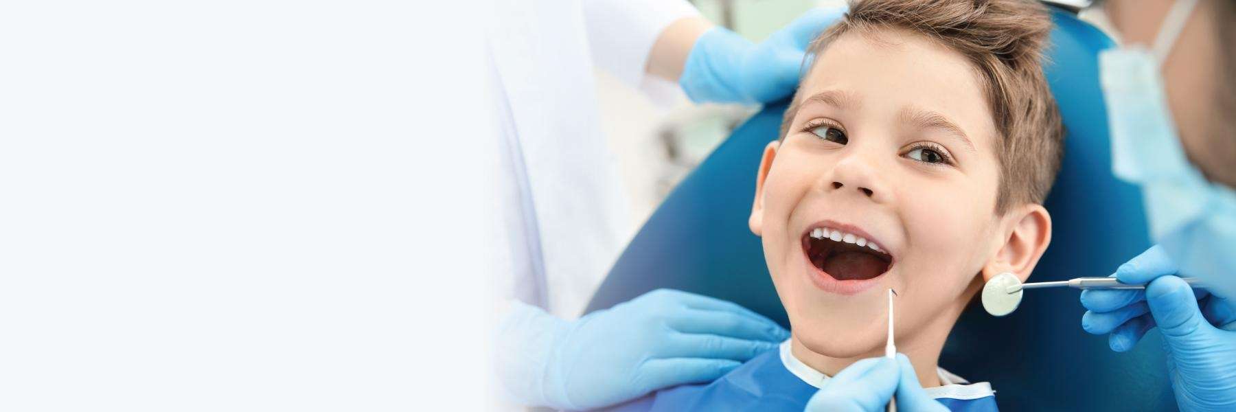 boy smiling in dentist exam chair | children's dentist cheshire ct